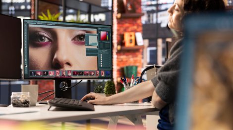 PAO expert en medias numeriques travaillant sur le montage photo avec un logiciel professionnel