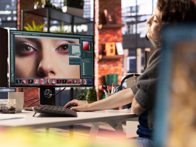 PAO expert en medias numeriques travaillant sur le montage photo avec un logiciel professionnel