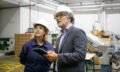 Confident bearded supervisor talking with female plant worker
